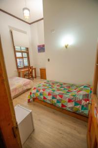 1 dormitorio con 2 camas y mesa. en Hospedaje y Espacio Cultural La Casa Del Puerto, Cerro Alegre, en Valparaíso