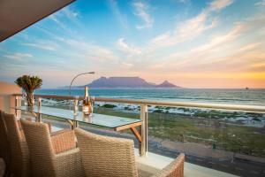 a balcony with a table and chairs overlooking the ocean at Sea Spray B306 in Bloubergstrand