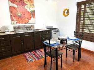 una cucina con tavolo, sedie e piano cottura di Quizur, Culturita de Paz a Piedades