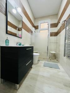 La salle de bains est pourvue d'une coiffeuse noire et d'une douche. dans l'établissement Isor Triana, à Las Palmas de Gran Canaria