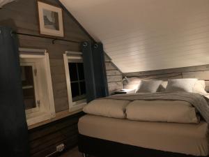 a bedroom with a bed and two windows at Lyngen Biarnes- Nordreisa in Hamnnes