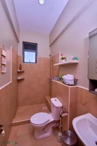 a bathroom with a toilet and a sink at Shosholoza Homes in Wakiso