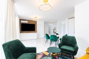 uma sala de estar com cadeiras verdes e uma mesa em Elysium Ocean Villa em Adeje