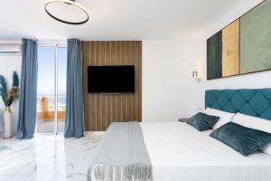 um quarto com uma cama grande e uma televisão na parede em Elysium Ocean Villa em Adeje