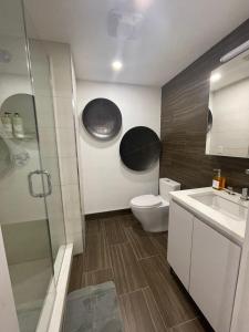 ein Bad mit einem WC, einem Waschbecken und einer Dusche in der Unterkunft Large 3 bedroom in Flatiron in New York