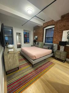 a bedroom with a bed and a couch and a tv at Large 3 bedroom in Flatiron in New York