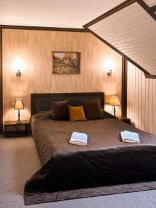 a bedroom with a large bed with two towels on it at Villa Blanc in Bukovel