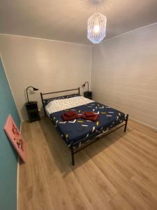 a bedroom with a bed with a blue comforter at Cottage les Écuries du faubourg in Béthune