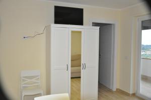 a room with a white cabinet with a television on top at La Vecchia Lanterna in Montecorvino Rovella