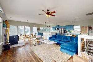 a living room with a blue couch and a kitchen at This Is It in Crescent City