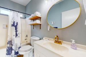 a bathroom with a sink and a mirror and a toilet at This Is It in Crescent City