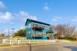 a blue house with a white fence in front of it at This Is It in Crescent City