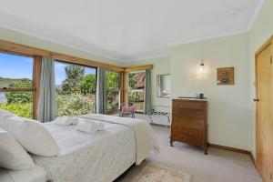 a bedroom with a bed and a large window at Okareka Lakefront in Rotorua