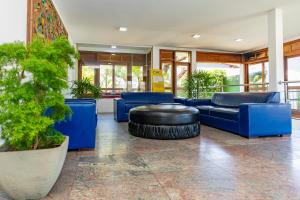 um hall de entrada com mobiliário azul e um grande pneu em Casa Blanca Park Hotel em Porto Seguro