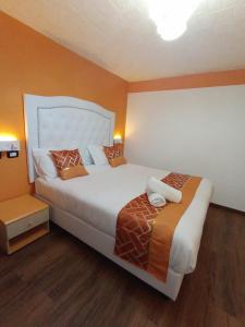 a bedroom with a large bed with orange walls at Hotel Veronese in Genova