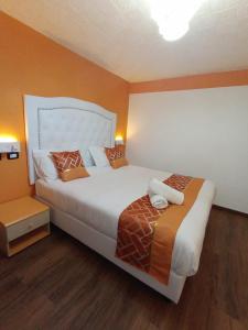 una camera da letto con un grande letto con pareti arancioni di Hotel Veronese a Genova