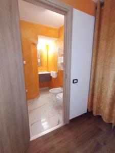 La salle de bains est pourvue de toilettes et d'un lavabo. dans l'établissement Hotel Veronese, à Gênes