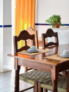a dining room table with two chairs and a wooden table at A Muralha in Tavira