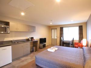 een keuken en een woonkamer met een bed in een kamer bij 388 Tay Motel in Invercargill
