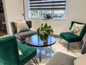 a living room with a table and green chairs at The Firs in Boston