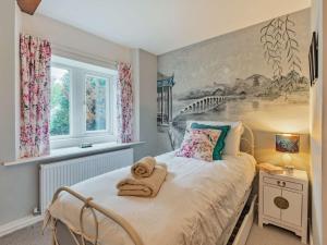 een slaapkamer met een bed met een schilderij aan de muur bij 5 Bed in Thorpe 85565 in Thorpe