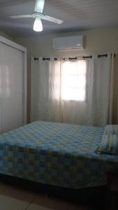 een slaapkamer met een bed en een plafondventilator bij casa privativa para família com ar condicionado in Olímpia
