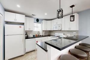a kitchen with white cabinets and black counter tops at Casa Havana @ Duval Square R22 in Key West