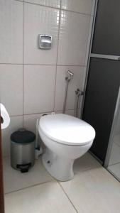 een badkamer met een wit toilet in een stal bij casa privativa para família com ar condicionado in Olímpia
