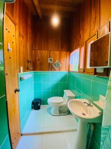 La salle de bains est pourvue de toilettes et d'un lavabo. dans l'établissement Wooden House Mindo - Casa de Las Nevadas, à Mindo