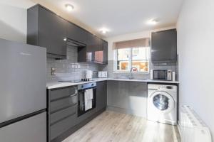 a kitchen with a washer and a washing machine at Stylish Retreat in Nuneaton Centre with Sofa Bed, Garden and Super Fast Wi-Fi in Nuneaton