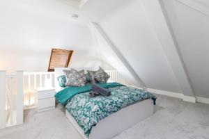 Stylish Retreat in Nuneaton Centre with Sofa Bed, Garden and Super Fast Wi-Fi في نيونياتون: غرفة نوم بسرير من الشرشف الاخضر والابيض