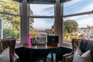 Zimmer mit einem Tisch vor einem großen Fenster in der Unterkunft Victorian Apartment With Sea Views By Adliv Host in Ramsgate