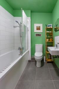 uma casa de banho com uma banheira, um WC e um lavatório. em Walpole Bay 2 Bed Stunning Garden Apartment em Margate