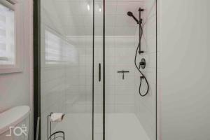 a shower with a glass door in a bathroom at Villa Scandinave 3 CAC avec 3 SDB privées & SPA in Pont-Rouge