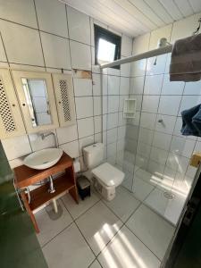 a bathroom with a toilet and a sink and a shower at Pousada do Luz in Imbituba +54 photos
