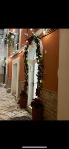 an alley with an arch with christmas decorations and plants at Porta Piccola Luxury Home in Bari