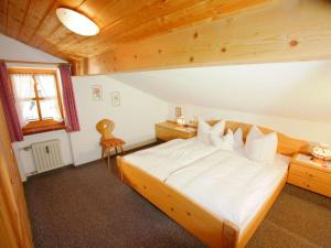 1 dormitorio con 1 cama grande y techo de madera en Haus Lux, en Reit im Winkl