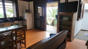 a living room with a couch and a television at Pousada Águas de Ibiraquera Suíte Ribanceira in Imbituba