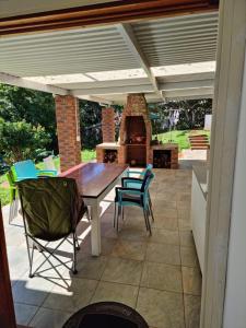 a patio with a table and chairs and a fireplace at 56 ArcherCrescent Cottage in Durban