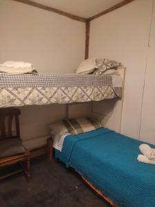 1 dormitorio con litera y 1 cama pequeña debajo en Enriqueta pds en Tolhuin