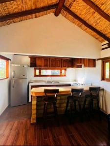 eine Küche mit einem Tisch und Stühlen sowie einem Kühlschrank in der Unterkunft Hermosa Cabaña Campestre el Palmar in Villa de Leyva