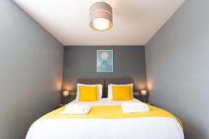 a bedroom with a large bed with yellow pillows at Stylish Home Close To The Beach By Adliv Host in Margate