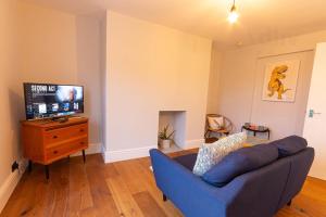 a living room with a blue couch and a tv at Old Town Trinity Apt No 4 By Adliv Host in Margate