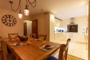 eine Küche und ein Esszimmer mit einem Holztisch und Stühlen in der Unterkunft Beautiful Margate Coastal Home With Parking in Margate