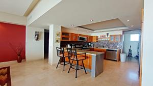 een keuken met een bar met krukken bij Encanto Living 304 Spacious, 2 Bedroom Ocean View!! in Playa Encanto