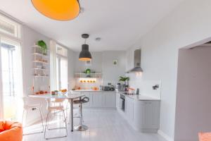 a kitchen with white cabinets and a table at Seaview Apartment By Turner Contemporary, Margate in Margate