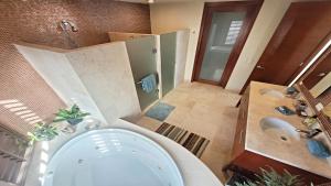 een grote badkamer met een bad en een wastafel bij Encanto Living 304 Spacious, 2 Bedroom Ocean View!! in Playa Encanto