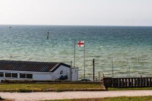 a canadian flag flying in front of the ocean at Seaview Apartment By Turner Contemporary, Margate in Margate