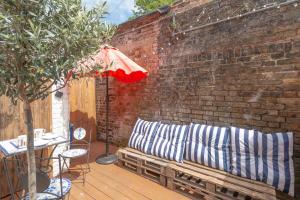 a wooden bench sitting next to a brick wall at 3-bed Hidden Gem Of A Cottage In Margate in Margate