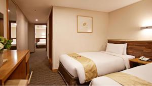 a hotel room with two beds and a desk at Hotel Skypark Myeongdong 1 in Seoul +45 photos